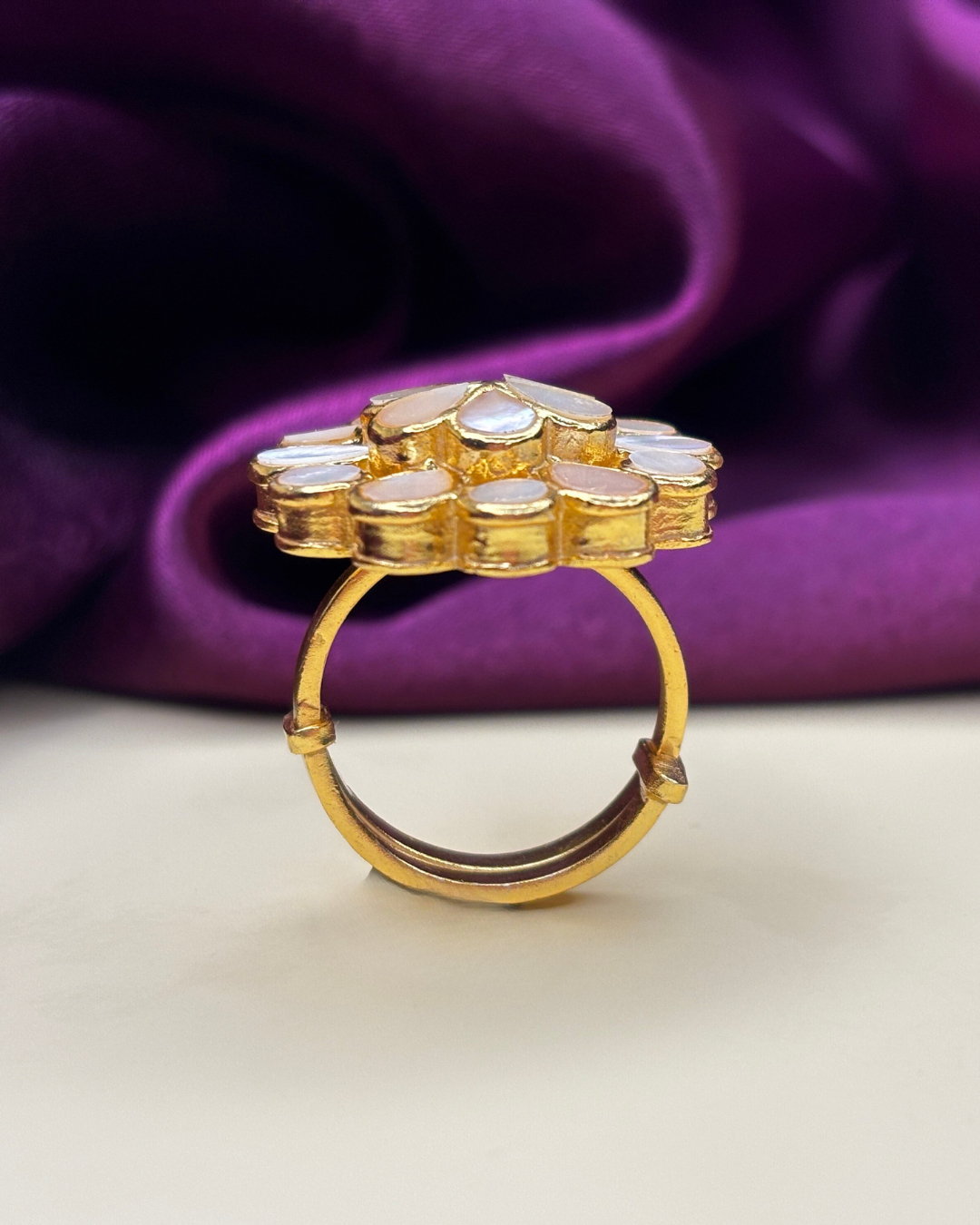 A gold ring with a cluster of white stone settings.