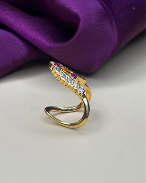 A gold-plated snake ring with clear cubic zirconia stones and small pink ruby.