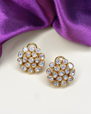 A pair of gold-toned stud earrings adorned with clear round and teardrop-shaped rhinestones.