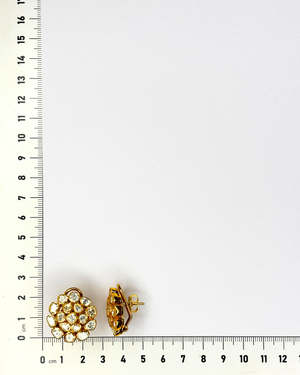 A pair of gold-toned floral cluster stud earrings with clear stones.
