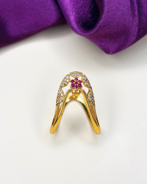 A gold ring with a curved, wing-like design, adorned with small clear stones