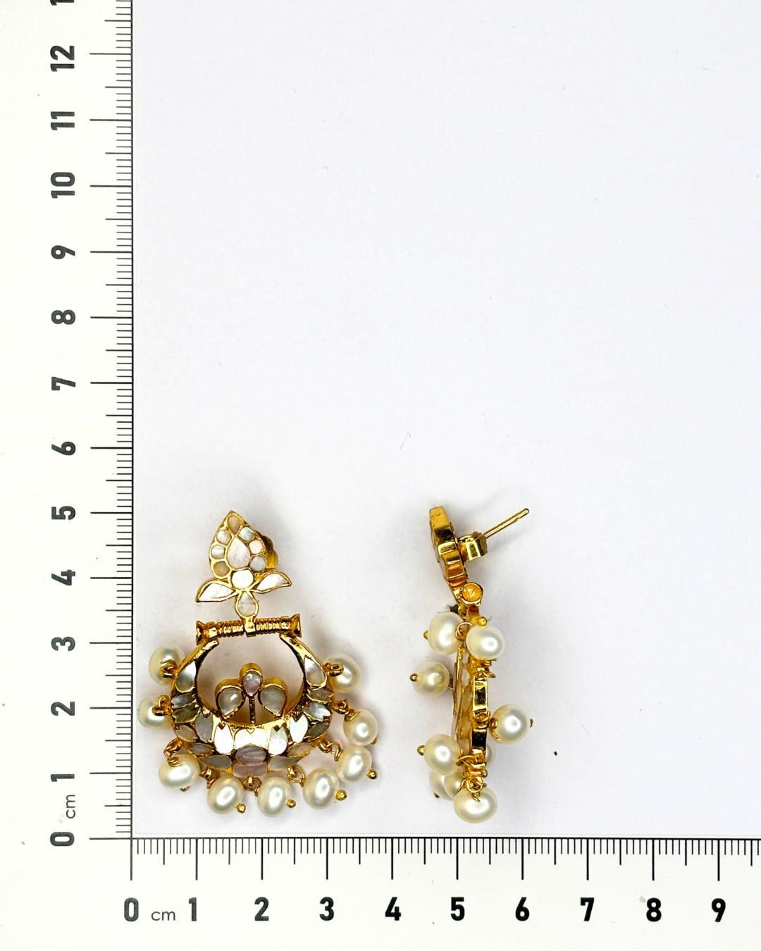 A pair of gold-toned statement earrings with white faux pearls.