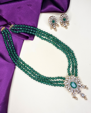 A green beaded necklace set with a matching pair of earrings.