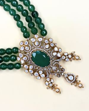 An ornate traditional Indian statement necklace featuring a large oval green stone.