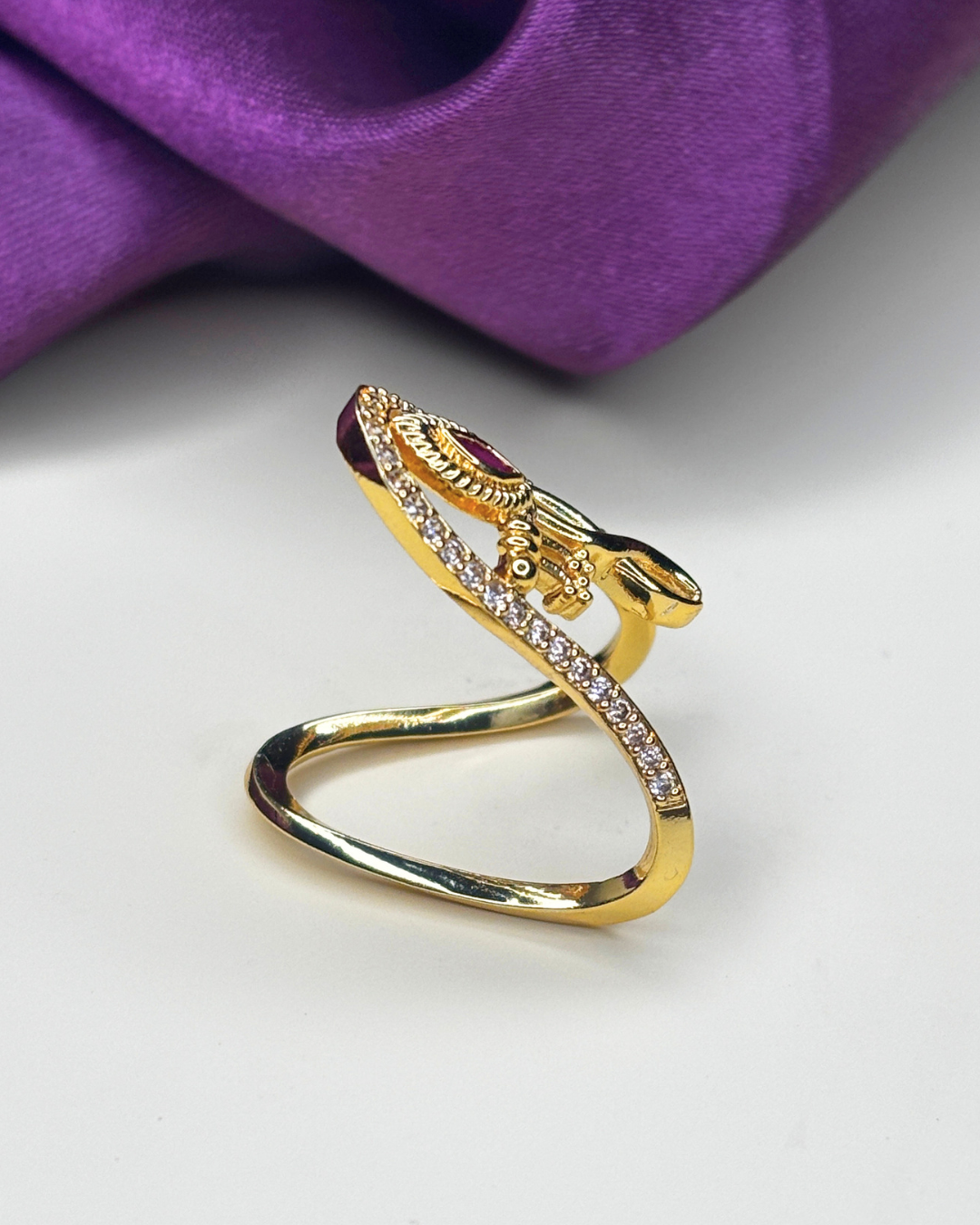 A gold snake ring with a central red gemstone.