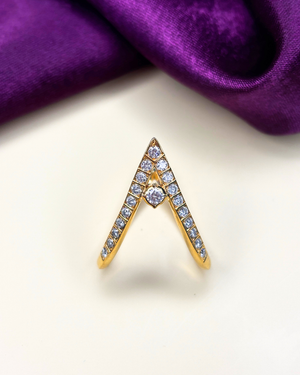 A gold ring designed in a V-shape, adorned with small clear pavé stones and a central round clear stone