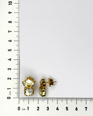 A pair of gold stud earrings with clear faceted stones.