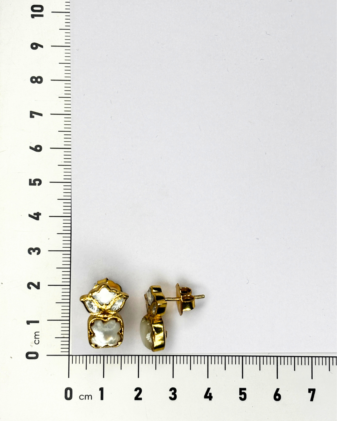 A pair of gold stud earrings with clear faceted stones.