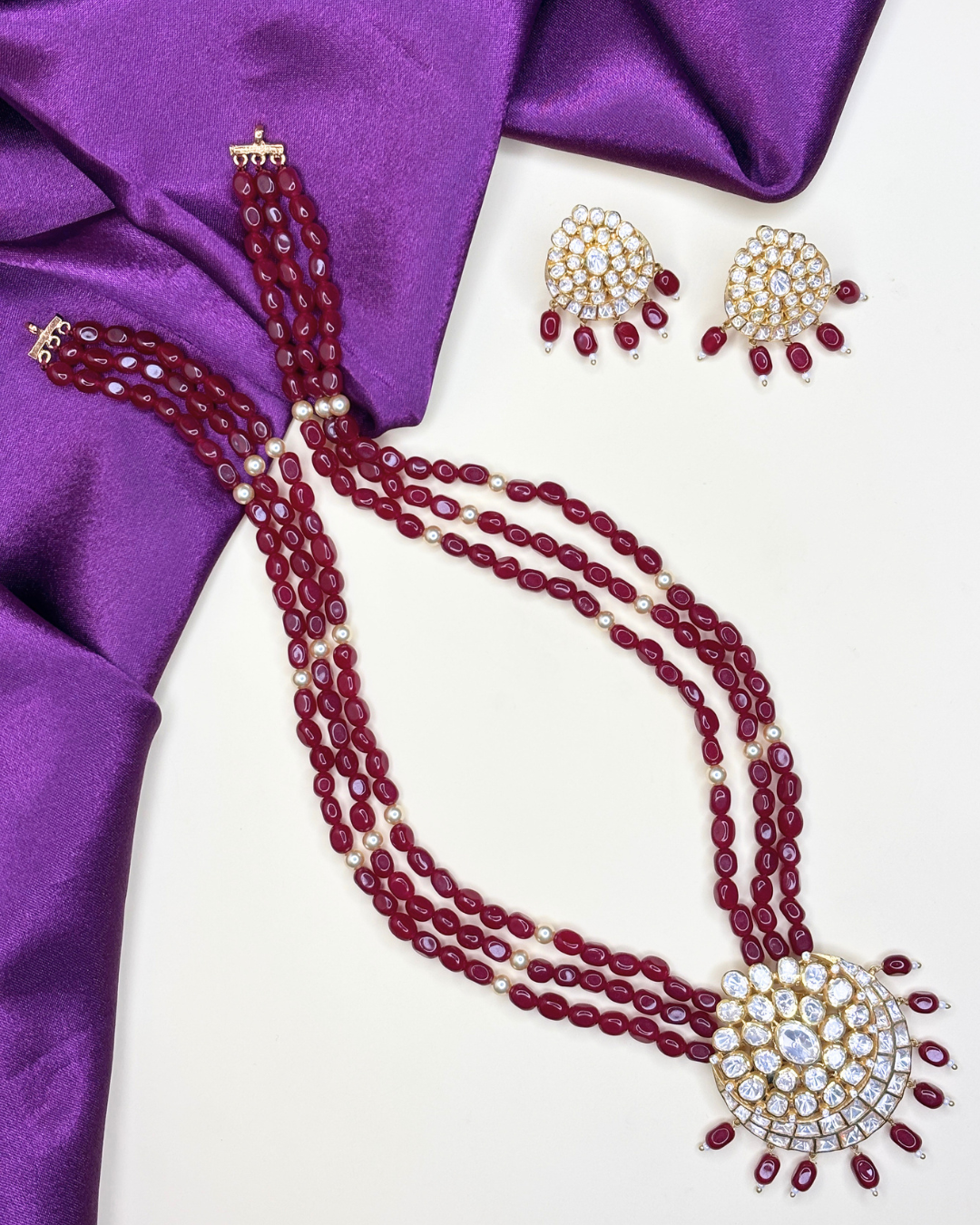 A traditional Indian jewelry set featuring a multi-strand necklace and matching earrings.