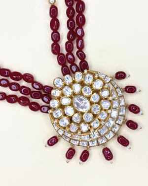A traditional Indian Kundan necklace featuring a large gold-plated circular pendant.