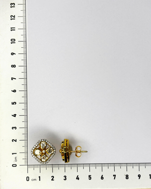 A pair of gold stud earrings with clear gemstones in a floral or diamond-cut