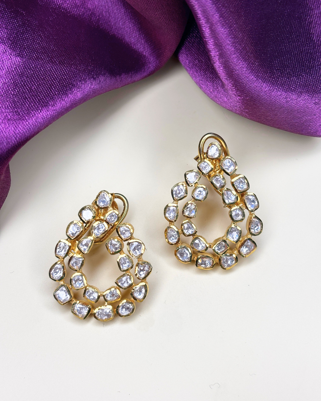 A pair of gold teardrop-shaped earrings.
